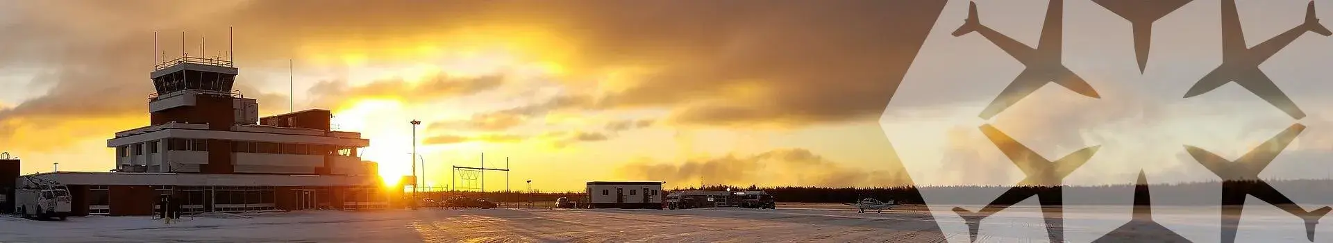 Airport terminal outside in winter with sun behind making sky glow